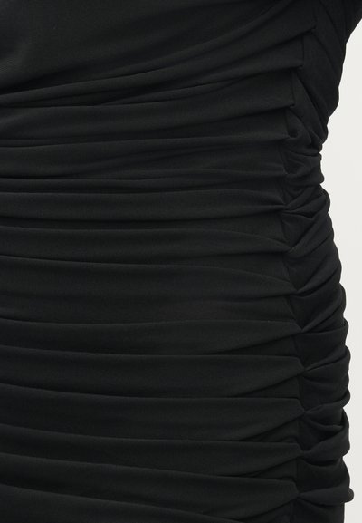 Vestido preto com detalhe de franzido horizontal, feito de um tecido suave. A textura apresenta pregas irregulares que criam uma forma ajustada.