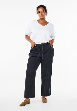 Black wide-leg pants with a drawstring waist, paired with a white short-sleeve V-neck shirt. The outfit features a relaxed fit and soft texture.