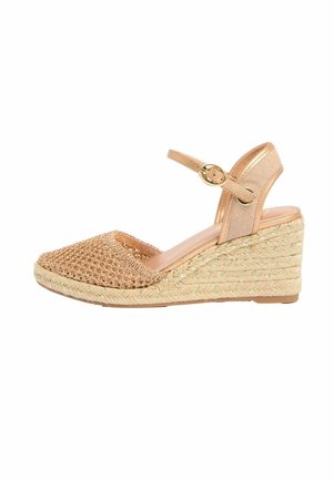 Kiilakorollinen espadrillosandaali, jossa on punottu vaaleanruskea varvasosa, kullanvärinen nilkkahihna ja punottu juttialusta.