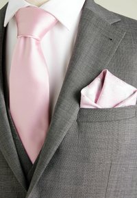 Grauer Anzug mit einer hellrosa Satin-Krawatte und einem Seiden-Taschentuch. Das Taschentuch hat ein dezentes Muster; das Hemd ist weiß mit einer strukturierten Oberfläche.