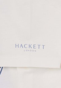 T-shirt en coton blanc avec un logo bleu "HACKETT LONDON". Conçu avec une texture lisse et un style col rond classique.