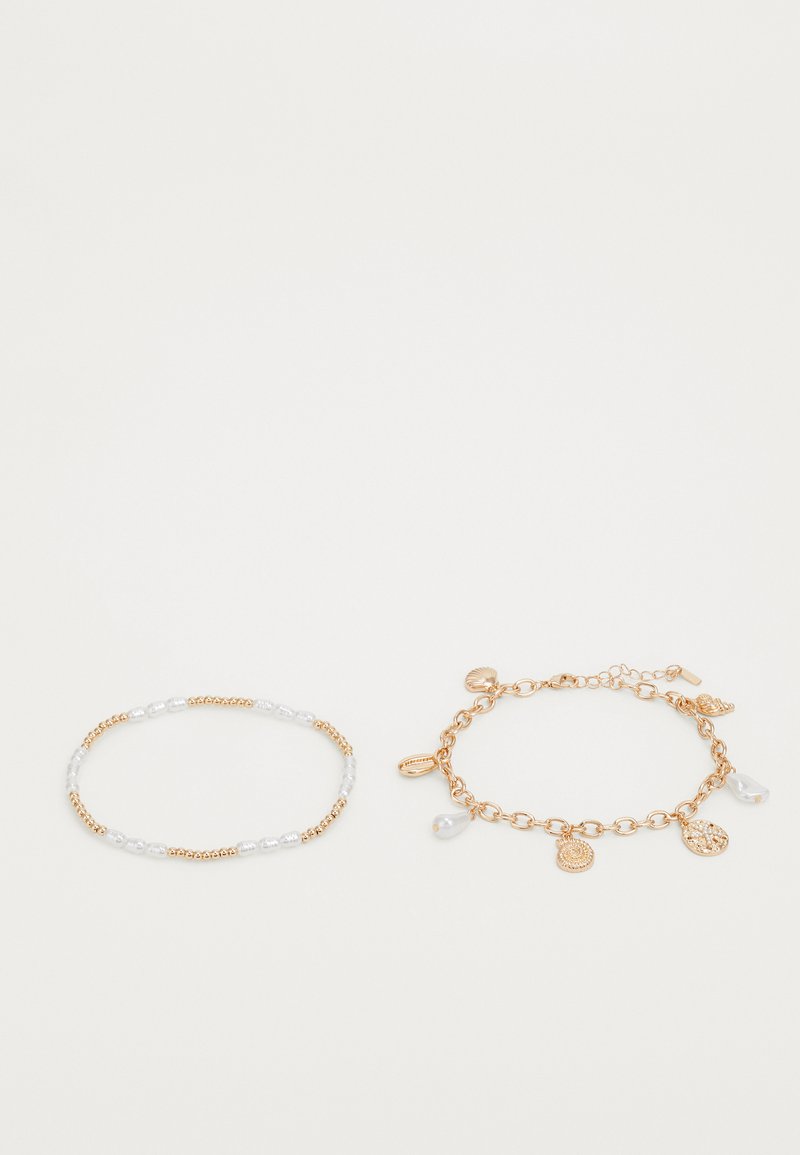 Gold-tone chain bracelet with charms, and a beaded bracelet featuring gold and clear beads. Textured design, with hanging accents.