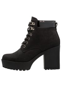 Black suede ankle boots with a chunky high heel, featuring silver hardware, round laces, and a glossy black accent at the ankle.