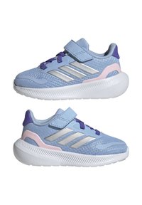 Chaussures de sport en mesh bleu avec des rayures argentées, des accents violets et des détails roses. Elles ont une semelle texturée blanche et une sangle Velcro.