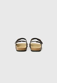 Sorte sandaler med to spenner, korkfotbed og gummisåle. Enkelt design med minimal detaljering, egnet for hverdagsbruk.