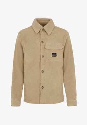 Beige fleece shirtjacket met een knoopsluiting aan de voorkant, kraag en een borstzak met een logo-patch. Zachte, textuurstof en een comfortabele pasvorm.