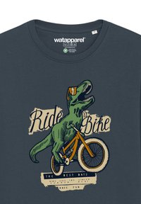 Donkerblauw t-shirt met een graphic van een groene dinosaurus die op een oranje fiets rijdt, met de tekst "Fiets" en speelse details.
