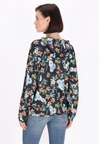 Zwarte hoodie met bloemenprint en een relaxte pasvorm, voorzien van kleurrijke bloemen en bladeren, lange mouwen en een aantrekkoord in de capuchon.