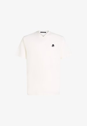 V-veida T-krekls off-white krāsā ar īsām piedurknēm, uz krūšu daļas ar mazs melns logotips. Vienkārša, gluda tekstūra.