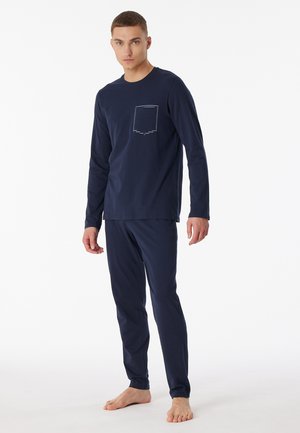 Navy blue cotton loungewear set features long sleeves, a chest pocket, and slim-fit pants with a smooth texture.