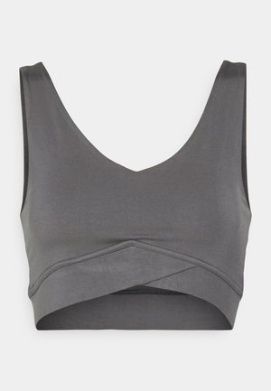 Grijze bralette met een diepe V-halslijn, een naadloos ontwerp en een crossover voorkant. Glad materiaal met een matte afwerking.
