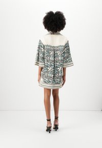 Rochie cu mânecă scurtă, în nuanțe de albastru deschis și crem, cu un model floral, având un guler și detalii decorative, atingând lungimea de mijloc a coapsei.