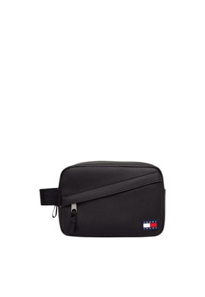 Bolsa de aseo negra rectangular con asa lateral, detalle de cremallera diagonal y pequeño parche con el logo de Tommy Jeans en la parte delantera inferior derecha.