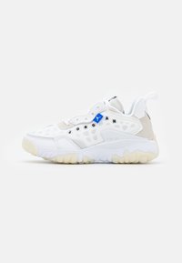 Vitt sportskor med en strukturerad överdel med utskärningar, en blå accent och en klumpig sula i gummi. Designen har en vadderad krage och plös.