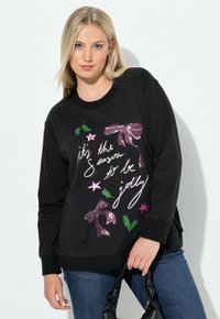 Sudadera negra con cuello redondo, que presenta un diseño gráfico en texto rosa y blanco, y elementos decorativos como lazos y estrellas.