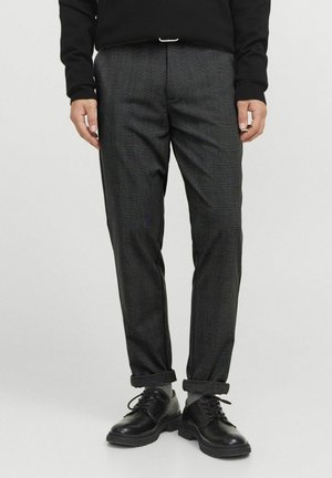 Pantalons à carreaux gris foncé avec une coupe ajustée, en tissu mélangé de coton, dotés de bordures roulées et associés à des chaussures noires à lacets.