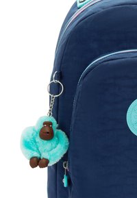 Marine rugzak met een pluizige turquoise gorilla sleutelhanger, gestructureerde stof, gekleurde ritsen en een ronde logodetail.
