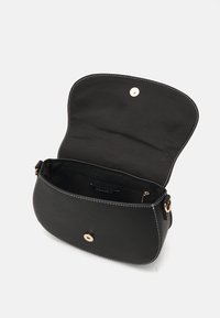 Musta nahkainen olkalaukku, jossa on kaareva muoto, kultaiset metalliosat, valkoiset tikkauskoristeet ja turvallinen nappisuljenta. Sisäpuolella on vetoketjullinen tasku.