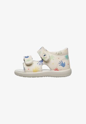 Sandale blanche pour enfants avec motifs de mains colorées, deux sangles Velcro réglables et une semelle en caoutchouc rembourrée.