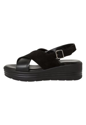 Sandalo nero con tomaia in suede e cinturino regolabile sul retro. Presenta una suola con plateau confortevole e un leggero tacco.