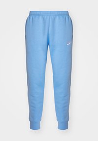Ljusblåa sweatpants med elastisk midja och ribbade muddar, med en liten vit Nike-logotyp på vänster lår.