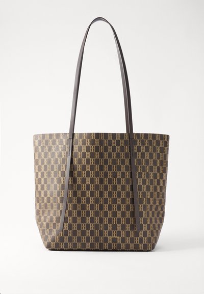 Geantă tote maro cu un model geometric, textură netedă și mânere lungi de culoare închisă. Detaliu cu logo auriu aproape de bază.