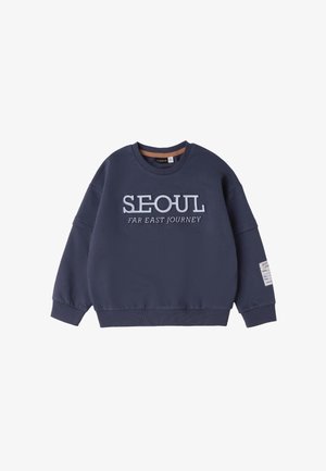 Marineblauer Rundhalsausschnitt Pullover mit dem Text "SEOUL FAR EAST JOURNEY" auf der Vorderseite und einem kleinen weißen Etikett am linken Ärmel.