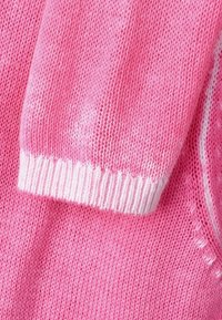 Light pink knitted sweater featuring a white ribbed cuff and a textured pattern, with smooth fabric and a relaxed shape.