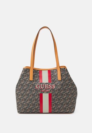 Bolso de mano Guess marrón con patrón y asas en color beige, con rayas verticales rojas y beige y el logo "GUESS EST. 1981" en la parte frontal.