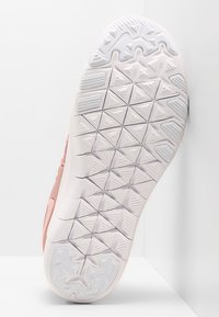 Podeszwa sneakersów, z teksturowanym białym gumowym spodem o geometrycznym wzorze bieżnika i różowymi akcentami wzdłuż boku.