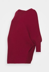 Pull en maille côtelée surdimensionné de couleur rouge profond avec un col bateau et des manches longues, conçu pour une coupe ample et confortable.