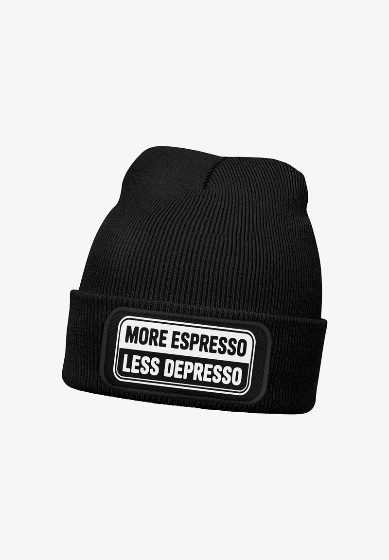 Schwarze Strickmütze mit umgeschlagenem Bündchen, das einen Aufnäher trägt, auf dem in fettem Schwarz-Weiß-Text steht: "MEHR ESPRESSO WENIGER DEPRESSO".