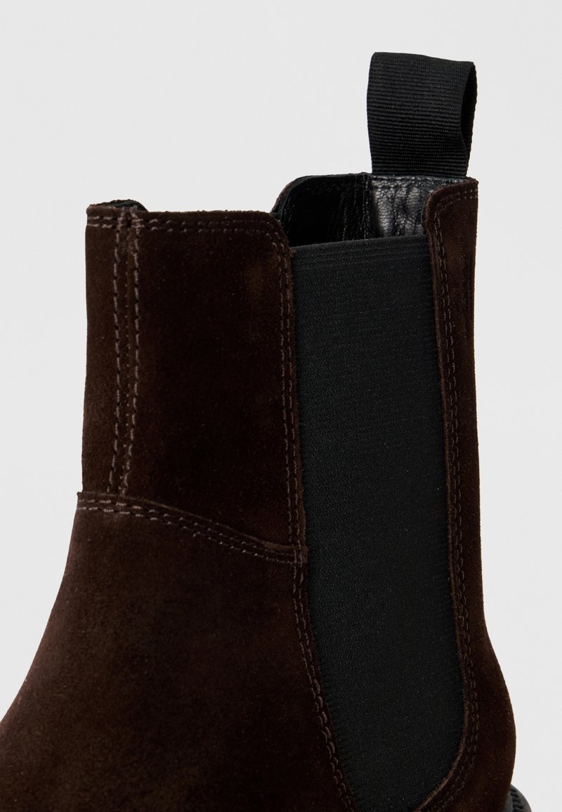 Braune Wildleder-Ankelstiefel mit elastischen Seitenpaneelen, Schlaufenlasche und kontrastierender schwarzer Innenseite. Verfügt über präzise Nähte entlang der Nähte.