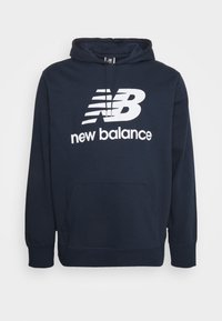 Laivastonsininen New Balancen huppari, jossa valkoinen logo ja teksti, edessä kengurusalkku ja säädettävä nyörillä kiristettävä huppu.