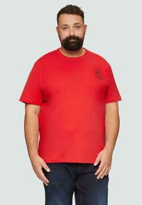 Rode katoenen t-shirt met korte mouwen, ronde hals, voorzien van een zwart bedrukt logo op de linker borst. Eenvoudig design, normale pasvorm.