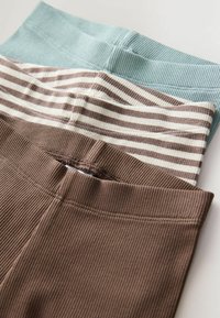 Drei Paar gerippte Leggings: ein hellblaues, ein braunes mit cremefarbenem Streifenmuster und ein einfarbiges dunkelbraunes. Alle verfügen über elastische Bundabschlüsse.