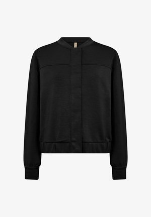 Must musta jope, mis on valmistatud pehmest kangast, millel on tõusva kaelusega, ees tõmblukk ja soonikkoes mansetid ja äär, et saavutada keha lähedane siluett.