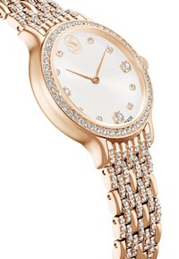 Zegarek w kolorze różowego złota z tarczą o srebrnym słonecznym wzorze, ozdobiony kryształkami, z teksturowaną metalową bransoletą.