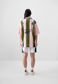 Reversible jersey in green and pink stripes, with "BOTTER" branding. Paired with white shorts featuring signatures and black accents.
