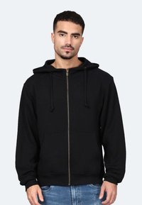 Felpa nera con zip e cappuccio regolabile, tasche frontali e una texture morbida. Presenta una zip dorata e polsini a coste.