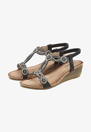 Sandali con tacco a forma di cuneo neri con un design a T di perline, caratterizzati da accenti argento e una soletta texturizzata. Fodera morbida e cinturini elastici alla caviglia.