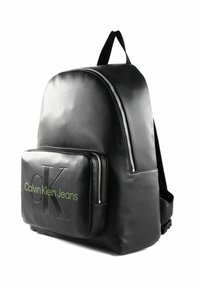 Zaino in finta pelle nera a forma arrotondata, con chiusura con zip, tasca frontale con logo in rilievo verde e spallacci regolabili.