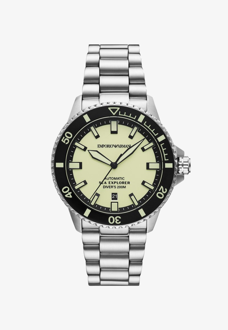 Srebrny zegarek ze stali nierdzewnej z czarną lunetą, świecącą w ciemności żółtą tarczą i prostokątnymi znacznikami godzin. Posiada mechanizm automatyczny oraz wyświetlacz daty.