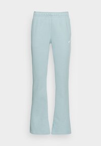 Světle modré tepláky s volným střihem, elastickým pasem a malým bílým logem Nike na levé straně. Hladká tkanina ze směsi bavlny.