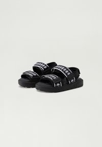 Svarte sandaler med justerbare stropper, med hvite logomønstre og en teksturert såle for godt grep. Laget av syntetiske materialer.