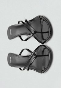 Sandalias de tacón alto negras con cuero lacado brillante, que cuentan con delgadas correas entrelazadas sobre el pie y una suela de plataforma contorneada.