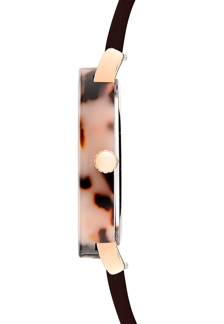 Uhrgehäuse mit Schildpattmuster und polierter silberner Kante, ausgestattet mit einem runden, goldenen Druckknopf und einem dunkelbraunen Armband.