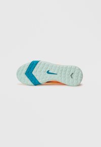 Suela de zapatilla deportiva de Nike en azul claro con patrones de agarre texturizados, destacando un acento en azul oscuro y una sección superior en naranja visible.