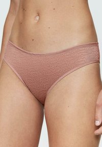 Jasnoróżowe kąpielówki z teksturowanym wzorem. Posiadają gładką talię oraz minimalistyczny design, wykonane z elastycznego materiału.