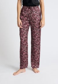Spodnie w kwiatowy deseń w kolorze burgundowym z czarnymi akcentami. Wykonane z lekkiego materiału, z luźnym krojem i elastycznym pasem dla komfortu.